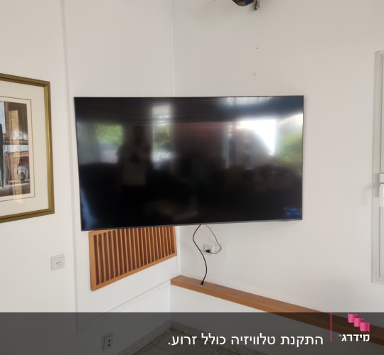 טלוויזיה תלויה על הקיר עם כבלים חשמליים